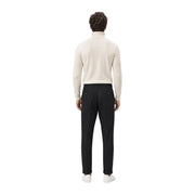 Un homme portant gianni lupo pantalon noir décontracté en polyester pour homme, associé à un pull à col roulé couleur crème