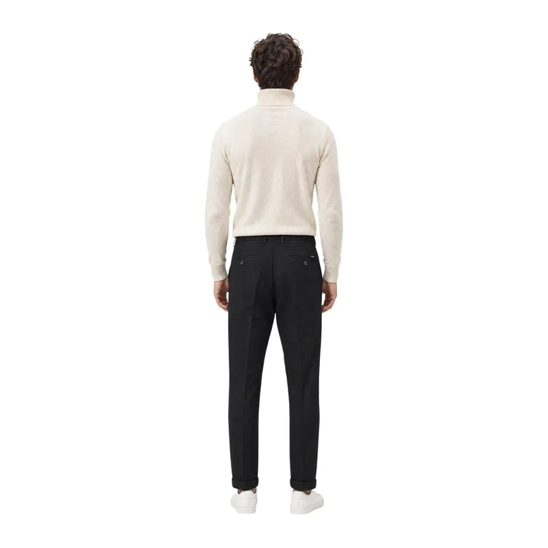 Un homme portant gianni lupo pantalon noir décontracté en polyester pour homme, associé à un pull à col roulé couleur crème