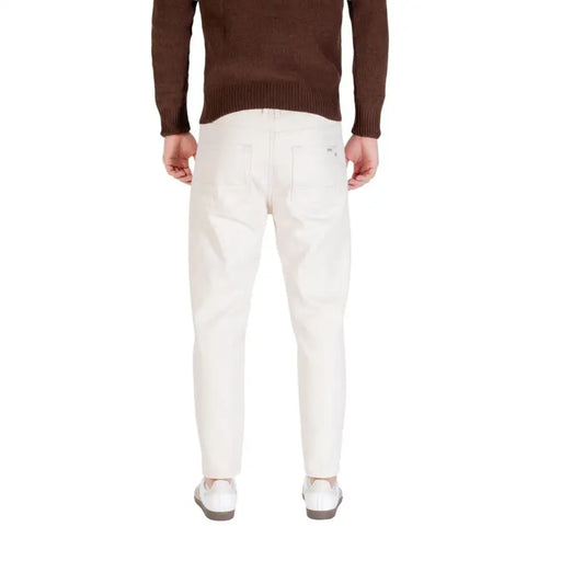 Pantalon en denim crème coupe slim en coton blanc avec une poche arrière épurée, vu de dos par Gianni Lupo