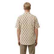 A man wearing a short-sleeved cream-colored Gianni Lupo men shirt with an intricate brown geometric pattern