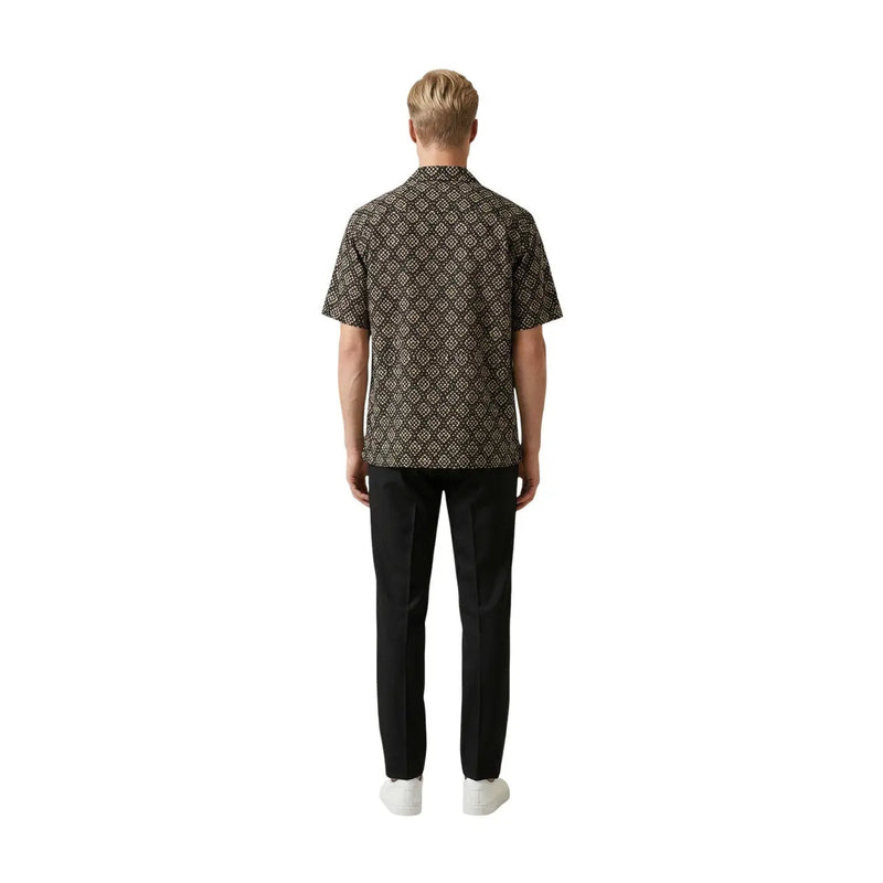 A man wearing a gianni lupo men shirt in dark brown with an intricate gold geometric pattern and short sleeves