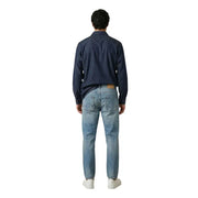 Un jean en denim clair délavé, coupe classique cinq poches et délavage subtil pour homme, par gianni lupo