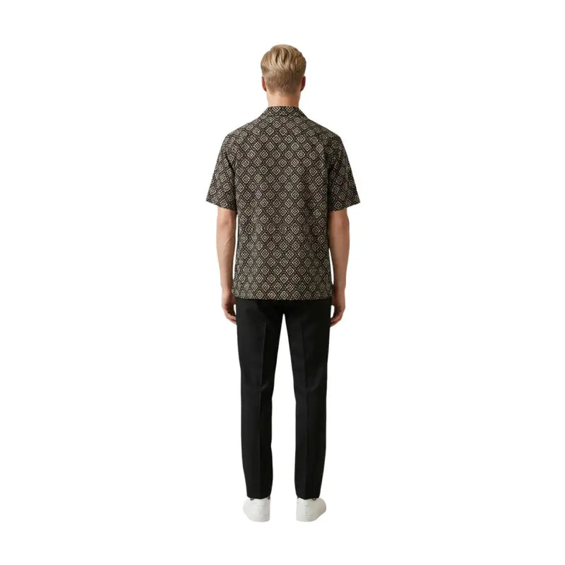 Un homme portant un gianni lupo Chemise homme marron foncé à manches courtes, ornée d'un motif géométrique doré complexe.