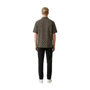 Un homme portant un Gianni Lupo Chemise homme marron foncé à manches courtes, ornée d'un motif géométrique beige complexe.