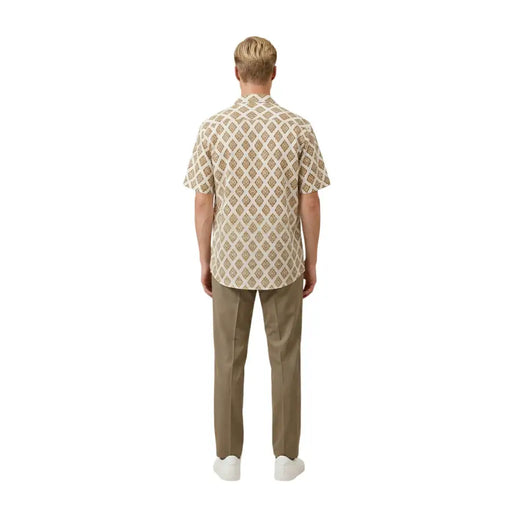 Un homme portant un beige Gianni Lupo Chemise pour homme à manches courtes, ornée d'un motif géométrique répété marron et crème.