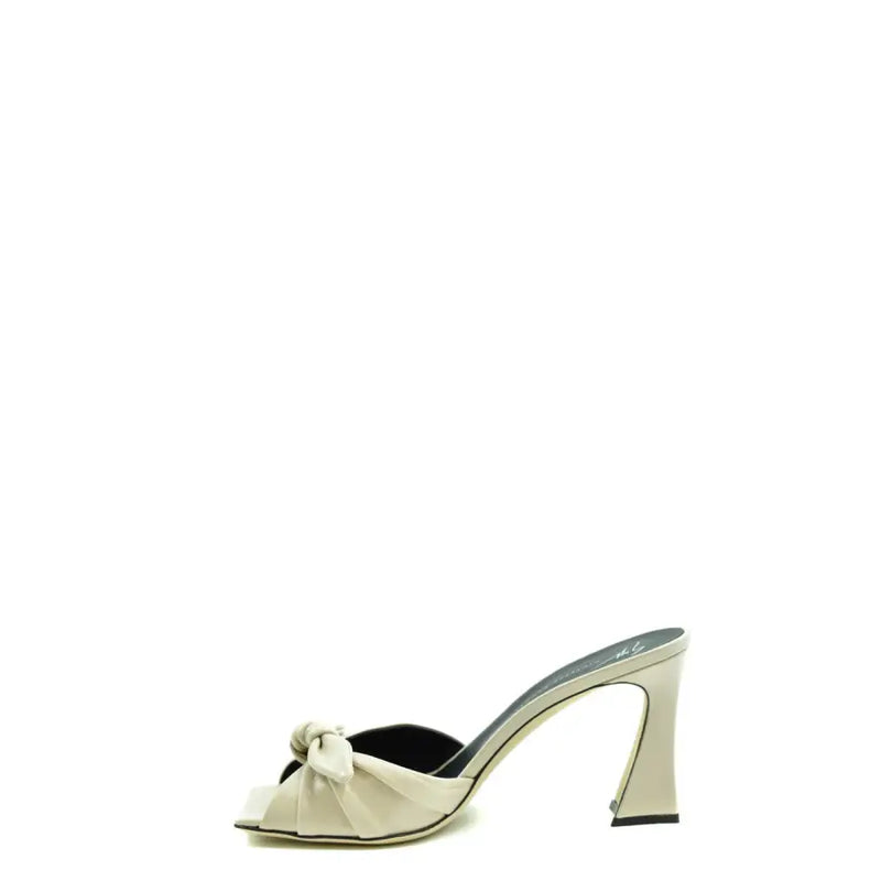 Mules Giuseppe Zanotti en satin crème à talon bloc, semelle intérieure noire et nœud décoratif sur le bout.