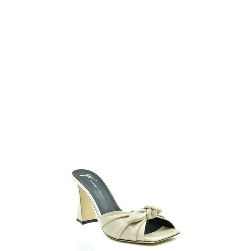 Mules Giuseppe Zanotti en cuir blanc à talon bloc, bout carré et détail nœud papillon, inspirées des mules en cuir beige.