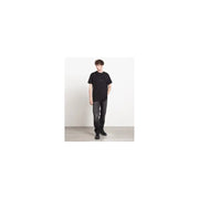 T-shirt noir à manches courtes t-shirt T-shirt avec logo minimaliste sur la poitrine, associé à un jean gris en coton Givenchy pour homme, taille IT 44.