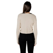 Beige ribbed knit long sleeve top with black trim at neckline shown with gold lurex button front cardigan with v neck