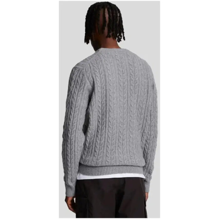 Gray cable-knit sweater displayed as a stylish and comfortable fall wardrobe staple