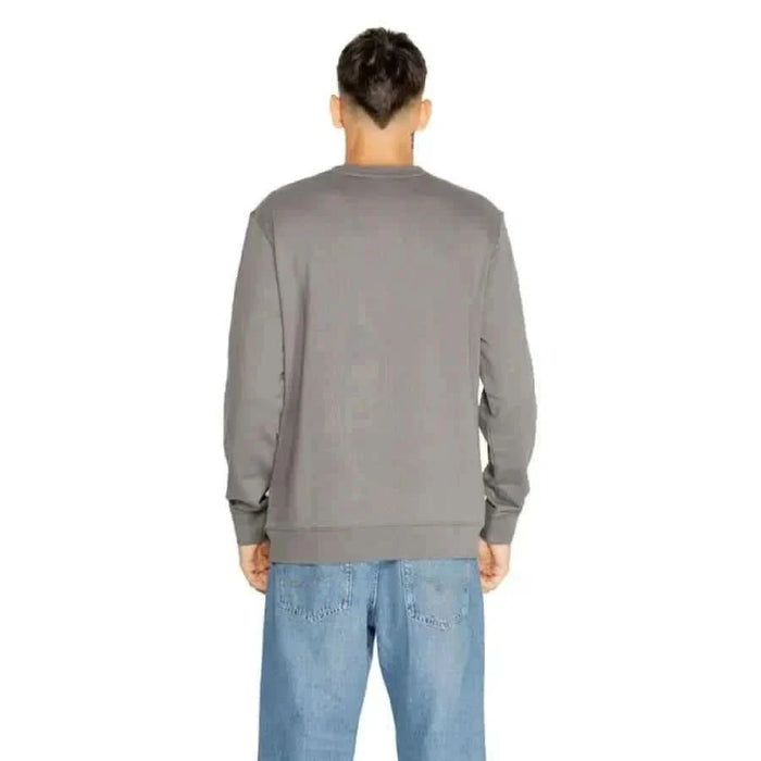 Gray long-sleeved sweatshirt worn by a person from behind in Boss Men Knitwear collection