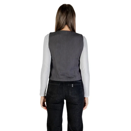 Gilet gris structuré porté sur une chemise gris clair à manches longues, gilet gris à col en V et boutons pour femme