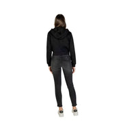 Guess Active women black full zip hooded sweatshirt with hood and long sleeves paired with dark gray skinny jeans