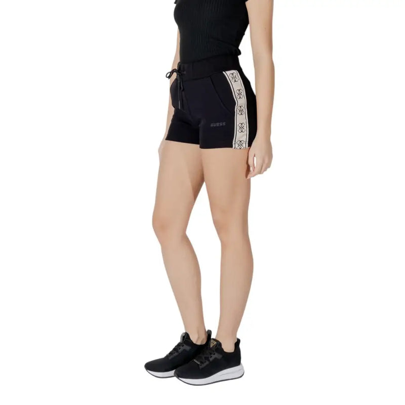 Black Guess active women’s shorts in cotton polyester blend with white patterned side stripe and brand logo on front