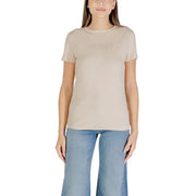 Women wearing beige short-sleeved T-shirt with light blue wide-leg jeans for Guess Active collection