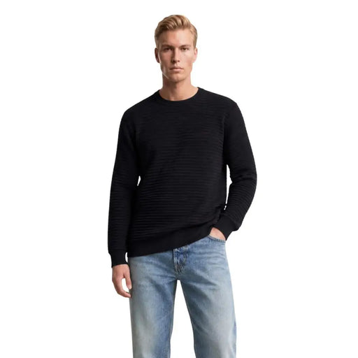 Guess Pull homme bleu en maille côtelée noire à col rond et manches longues, idéal pour une tenue décontractée.