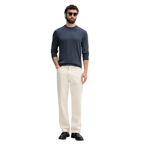 Guess Pull homme bleu marine à manches longues et col rond, confectionné dans un tissu tricoté doux pour une tenue décontractée.