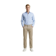Un homme vêtu de beige Guess pantalon slim en mélange de coton porté avec une chemise bleu clair à boutons
