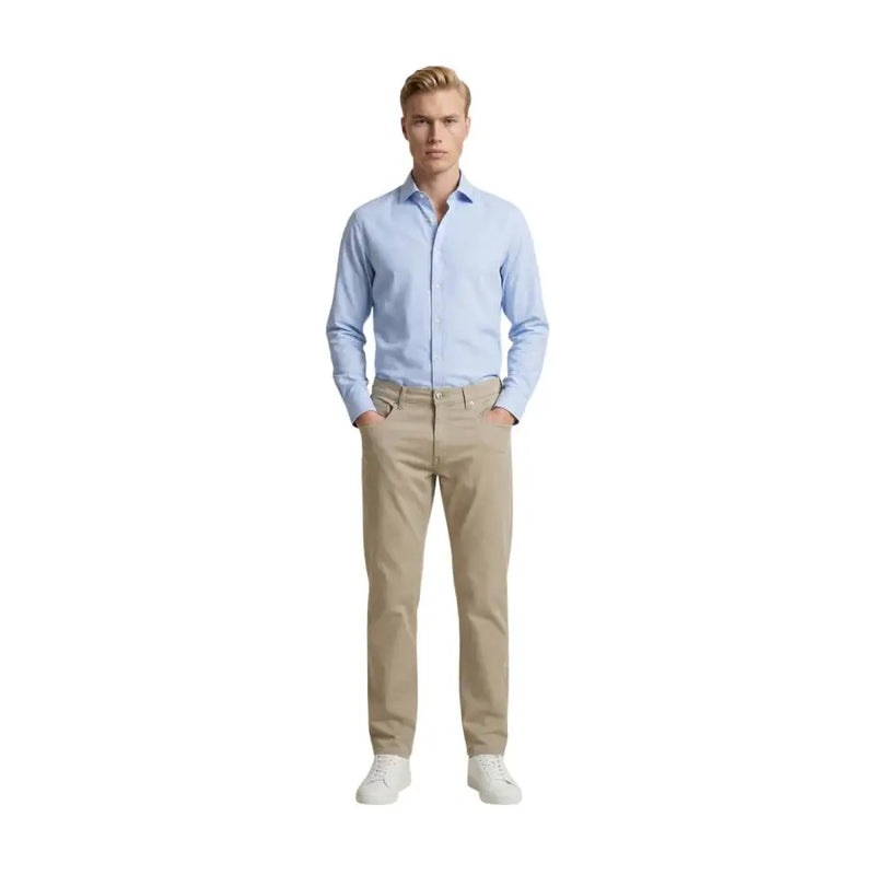 Un homme vêtu de beige Guess pantalon slim en mélange de coton porté avec une chemise bleu clair à boutons