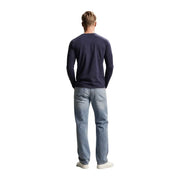 Guess T-shirt homme bleu marine slim fit à manches longues en coton, porté avec un jean en denim clair (vue de face)