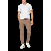 Un pantalon chino beige slim fit à plis discrets, porté par un mannequin. guess T-shirt blanc à col rond pour homme