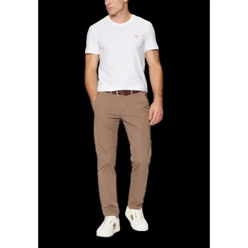 Un pantalon chino beige slim fit à plis discrets, porté par un mannequin. guess T-shirt blanc à col rond pour homme