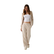 Guess Pantalon de survêtement beige à lacets pour femme, en mélange modal, avec veste assortie ornée de détails de texte vertical sur les manches et les coutures.
