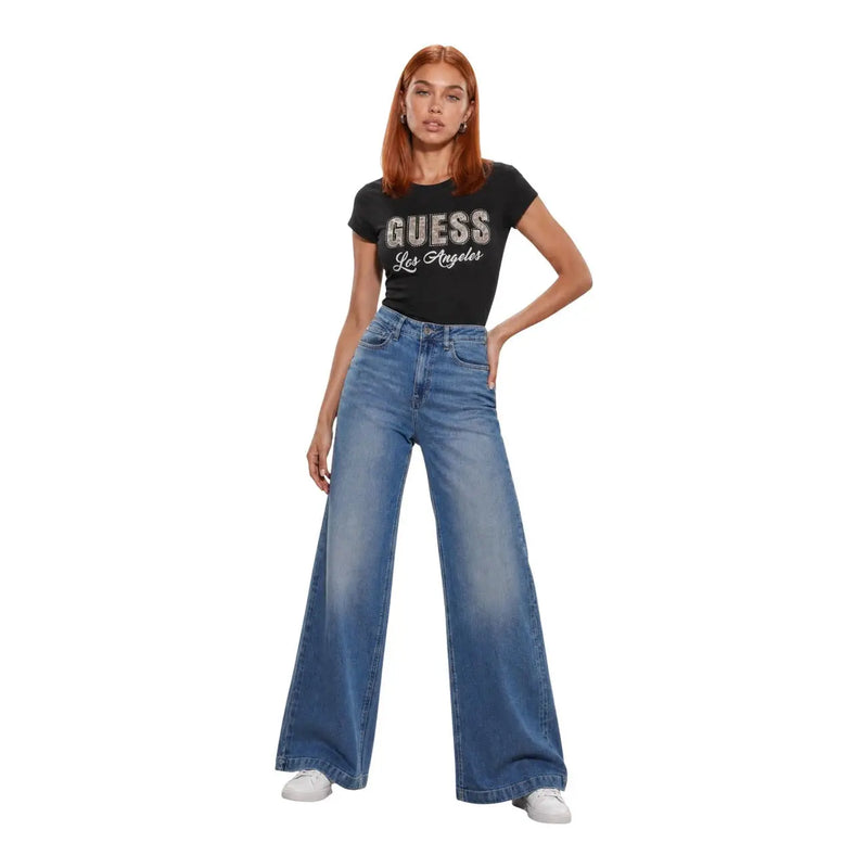 Noir Guess T-shirt graphique Los Angeles avec inscription en sequins argentés, porté avec un jean Bellagio bleu en coton mélangé pour femme.