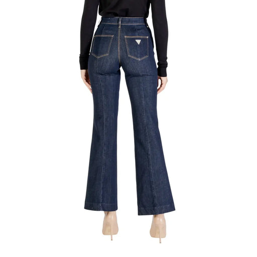 Vue arrière de guess Jean slim en coton denim bleu foncé pour femme, pantalon évasé avec un discret logo triangulaire blanc sur la poche