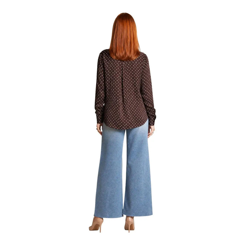 A woman wears a Guess women brown polyester blouse with classic long sleeves and small white polka dots