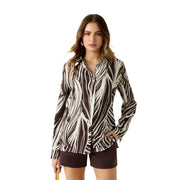 A woman wears a Guess women brown viscose long classic round neck shirt with bold black and white leaf patterns