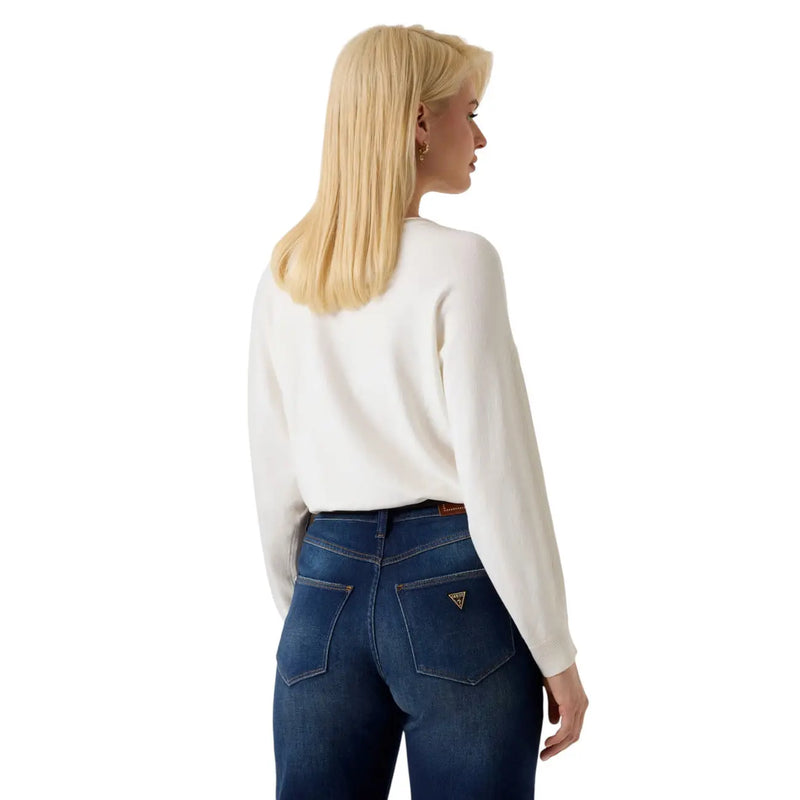 Guess Pull blanc en maille pour femme, manches chauve-souris, mélange viscose, porté avec un jean bleu foncé (vue de face)