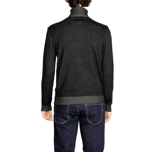 Charcoal heathered turtleneck sweater with ribbed cuffs and hem, dark wash denim jeans.