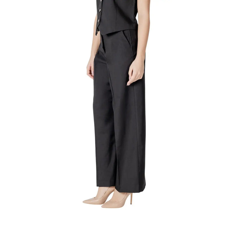 Ichi Pantalon noir en coton pour femme, avec poches, coupe ajustée élégante et plis latéraux discrets.