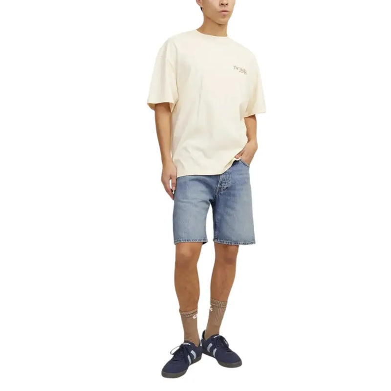 Cream-colored oversized short-sleeved t-shirt with small embroidered logo paired with jack & jones light blue cotton polyester shorts for men