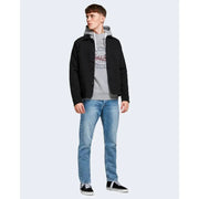 Veste noire boutonnée à capuche et poches avant, portée avec un jean bleu Jack & Jones pour homme, 100 % coton.