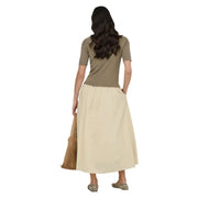 A woman wears a beige cotton maxi skirt by Jacqueline de Yong with a pleated waistband and subtle side pockets