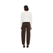 Une femme porte un jean Jacqueline De Yong marron en coton, associé à un pull crème. top