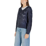 Woman wearing Jacqueline De Yong long blue V-neck knit sweater with white t-shirt and light wash jeans