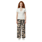 Une femme portant un pantalon large en viscose à dentelle florale noire de Jacqueline de Yong et un haut blanc à manches courtes top