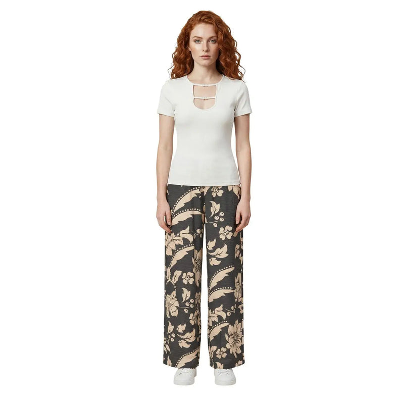 Une femme portant un pantalon large en viscose à dentelle florale noire de Jacqueline de Yong et un haut blanc à manches courtes top