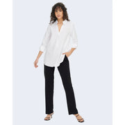 Chemise blanche oversize à manches retroussées et col en V, portée avec un pantalon noir en polyester Jacqueline de Yong.