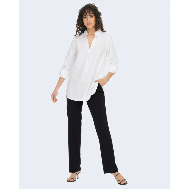 Chemise blanche oversize à manches retroussées et col en V, portée avec un pantalon noir en polyester Jacqueline de Yong.