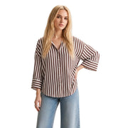A woman wears a jdy women brown viscose round neck shirt with 3/4 sleeves and vertical brown and cream stripes