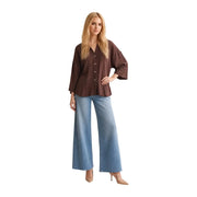 A woman wearing a JDY women brown viscose round neck classic shirt with wide sleeves and light blue denim trousers