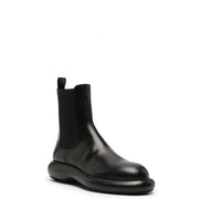 Bottines Jil Sander pour homme en cuir noir, à semelle épaisse et empiècements élastiques latéraux, collection automne-hiver.