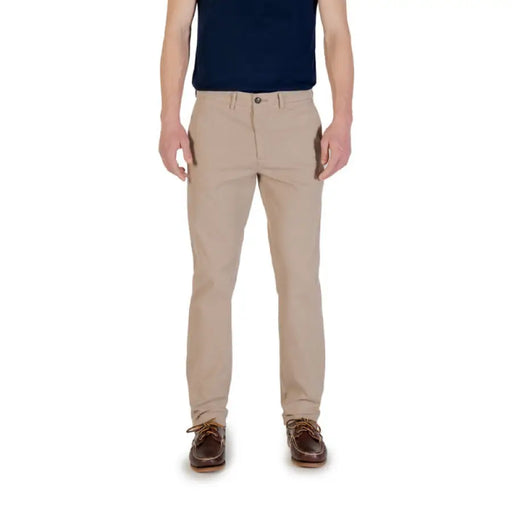 Khaki-colored men’s casual pants paired with brown boat shoes for a stylish look