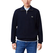 Pull Lacoste bleu marine en coton pour homme, demi-zip, avec logo crocodile vert sur la poitrine, idéal pour une tenue décontractée.