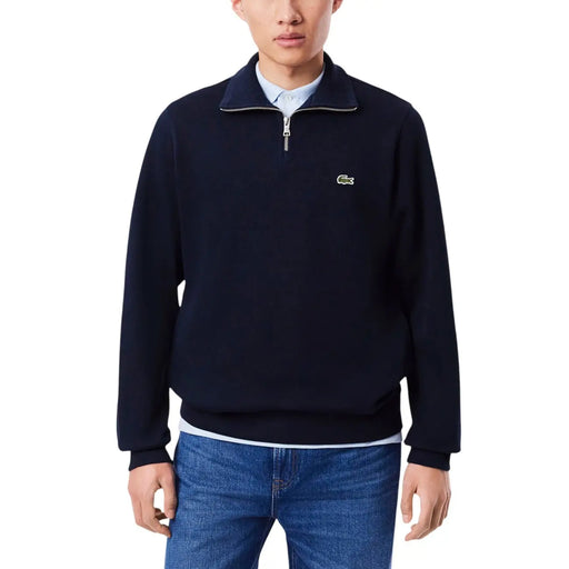Pull Lacoste bleu marine en coton pour homme, demi-zip, avec logo crocodile vert sur la poitrine, idéal pour une tenue décontractée.