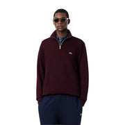 Pull Lacoste bordeaux en coton à demi-zip pour homme, orné d'un discret logo crocodile vert sur la poitrine, idéal pour un look décontracté.